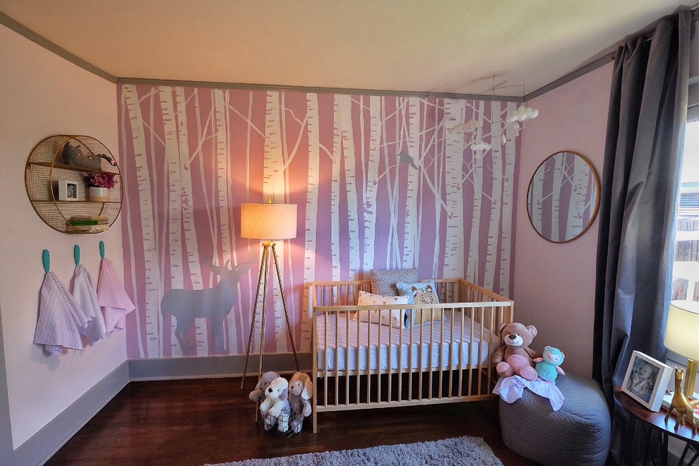 Modelo de habitación de bebé niña actual pequeña con paredes rosas y suelo de madera oscura