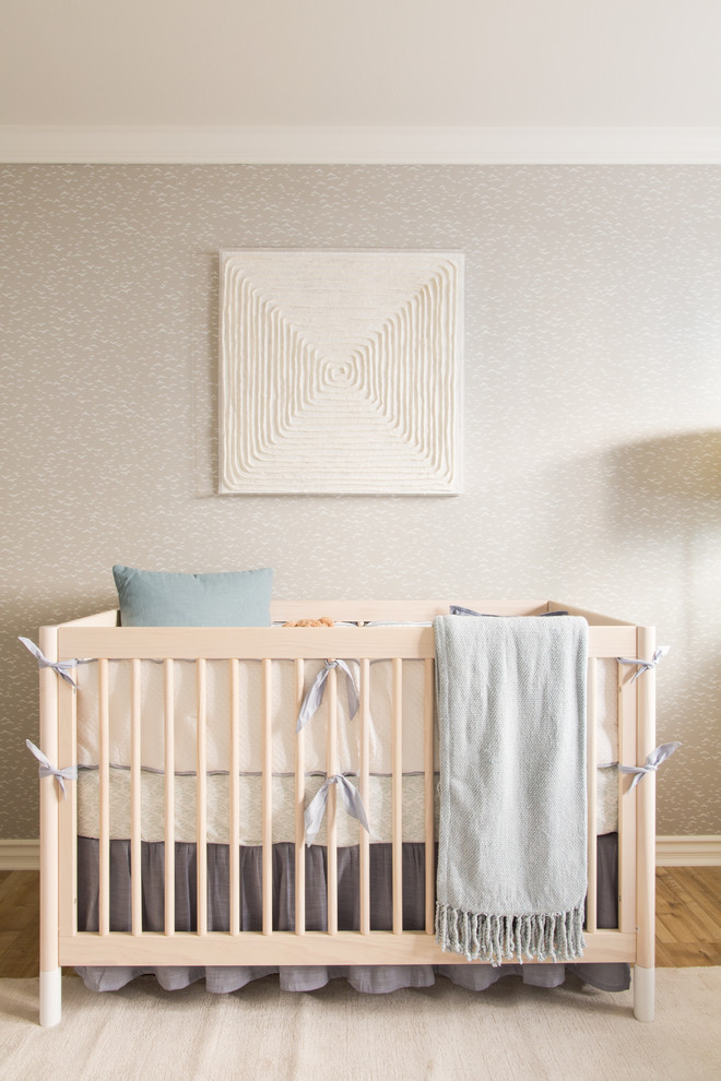Photo of a large modern nursery for boys in Los Angeles with grey walls and light hardwood flooring.