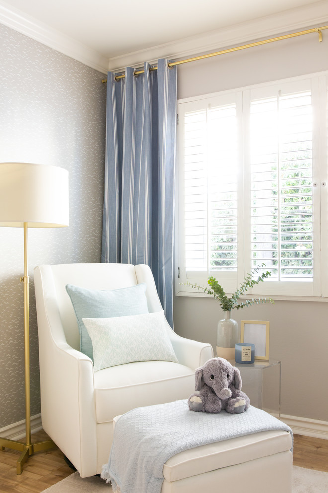 Immagine di una grande cameretta per neonato moderna con pareti grigie e parquet chiaro