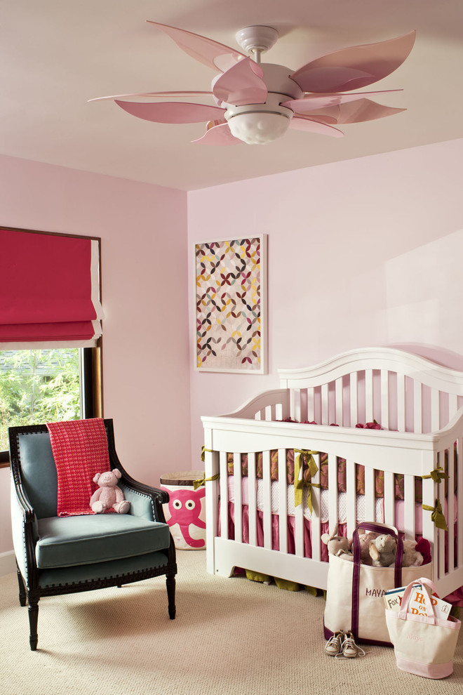 Immagine di una cameretta per neonata tradizionale con pareti rosa, moquette e pavimento beige