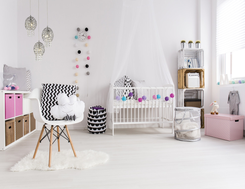 Inspiration pour une chambre de bébé fille design de taille moyenne avec un mur blanc et sol en stratifié.