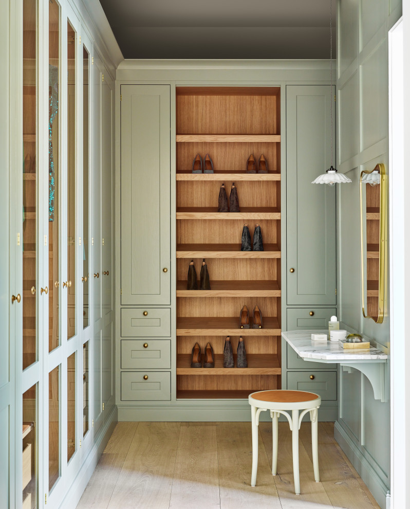 Идея дизайна: гардеробная комната среднего размера, унисекс в стиле неоклассика (современная классика) с зелеными фасадами