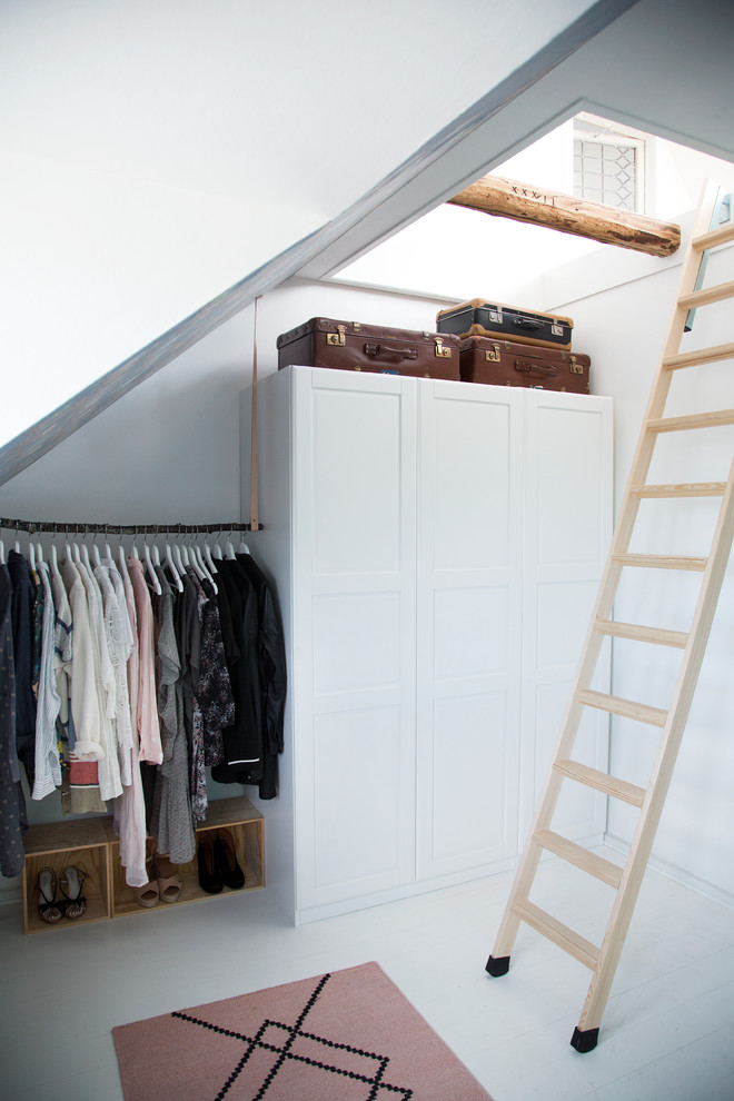 Imagen de vestidor unisex nórdico de tamaño medio con armarios estilo shaker, puertas de armario blancas y suelo de madera pintada