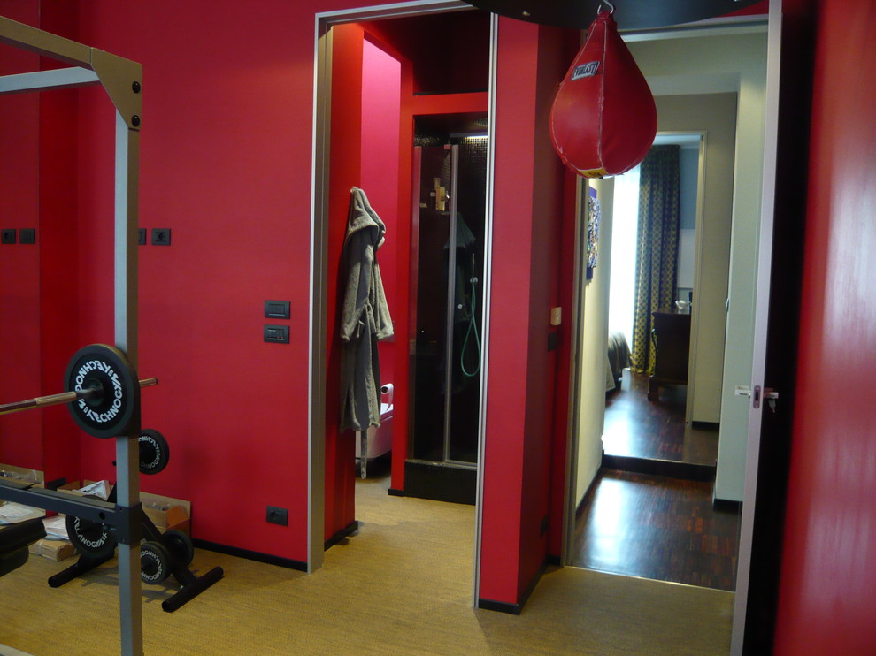 Moderner Fitnessraum mit roter Wandfarbe in Turin