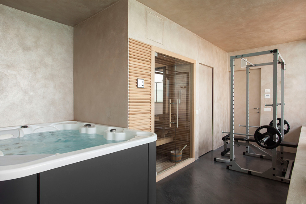 Moderner Fitnessraum mit beiger Wandfarbe und grauem Boden in Mailand