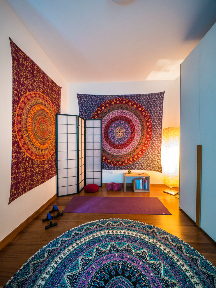 Inspiration pour un studio de yoga bohème de taille moyenne avec un mur blanc et un sol en bois brun.