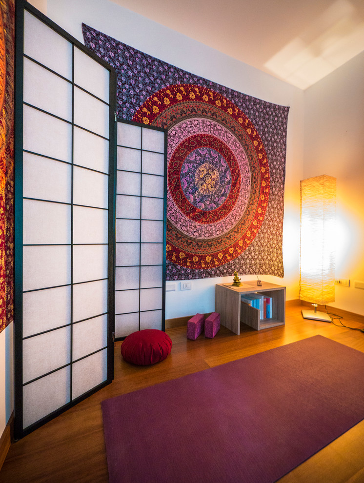Mittelgroßer Eklektischer Yogaraum mit weißer Wandfarbe und braunem Holzboden in Mailand