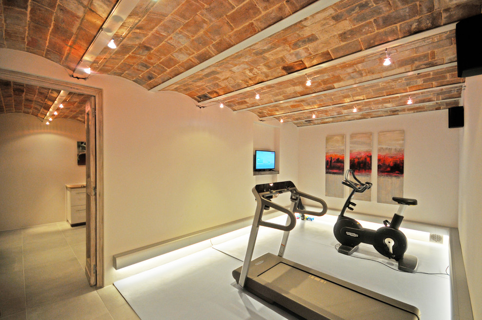 Geräumiger Uriger Fitnessraum mit beiger Wandfarbe, Porzellan-Bodenfliesen und beigem Boden in Sonstige