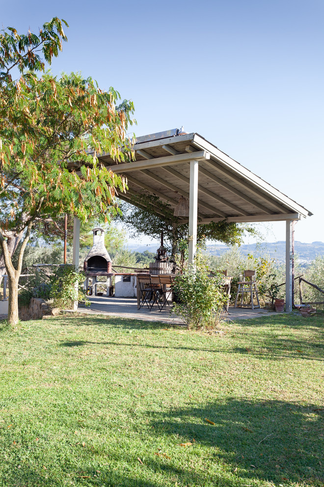 Foto de patio de estilo de casa de campo en patio trasero con cocina exterior y pérgola