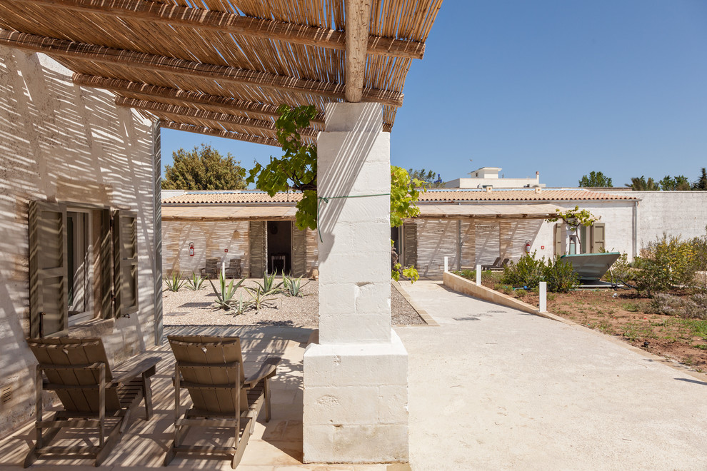 Cette image montre une terrasse méditerranéenne avec une cour, des pavés en brique et une pergola.
