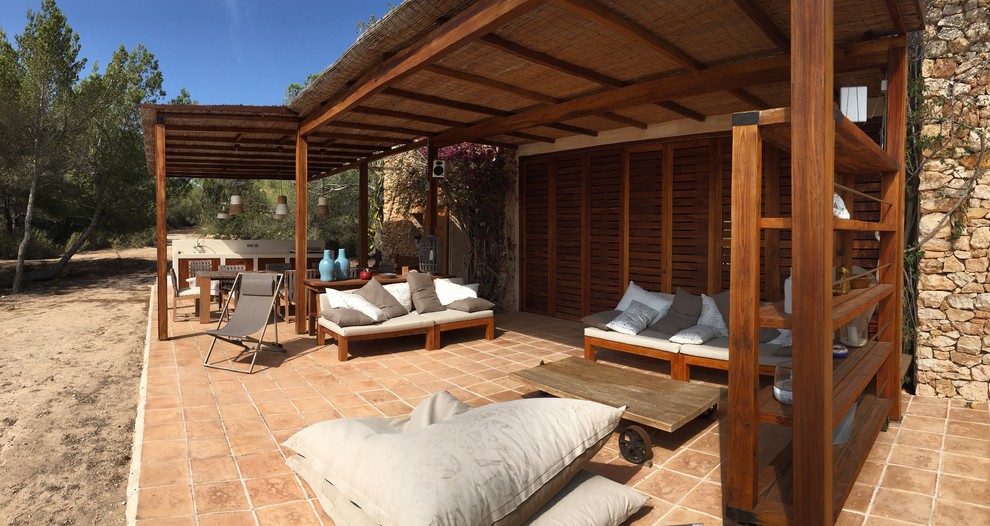 Modelo de patio mediterráneo grande en patio trasero con cocina exterior, suelo de baldosas y pérgola