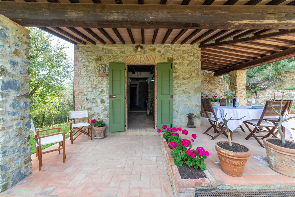 This is an example of a rural back patio in Florence with tiled flooring and a roof extension.