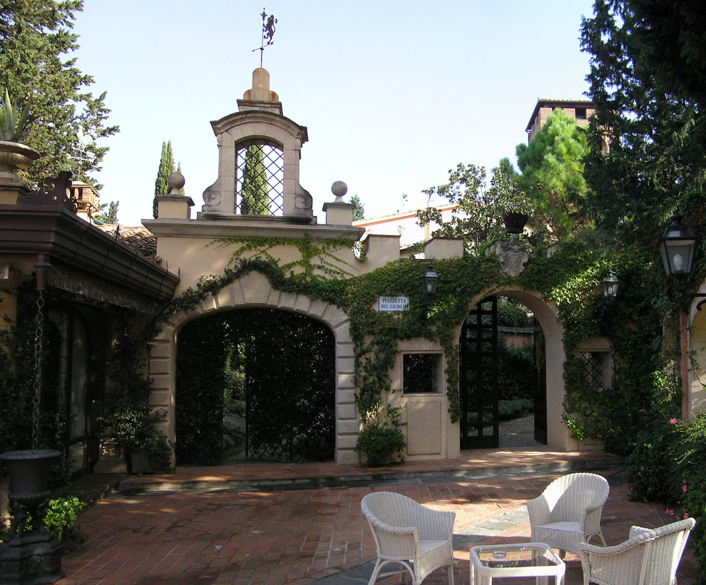 Esempio di un grande patio o portico country nel cortile laterale con pavimentazioni in mattoni