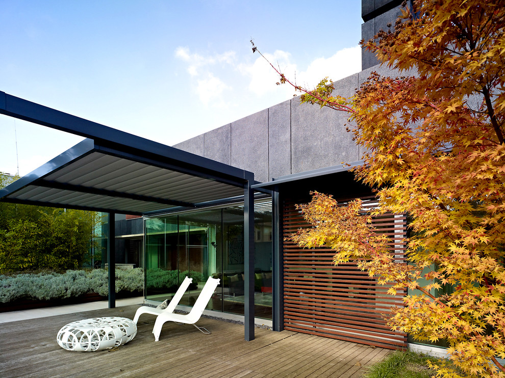 Immagine di un patio o portico moderno con pedane e una pergola