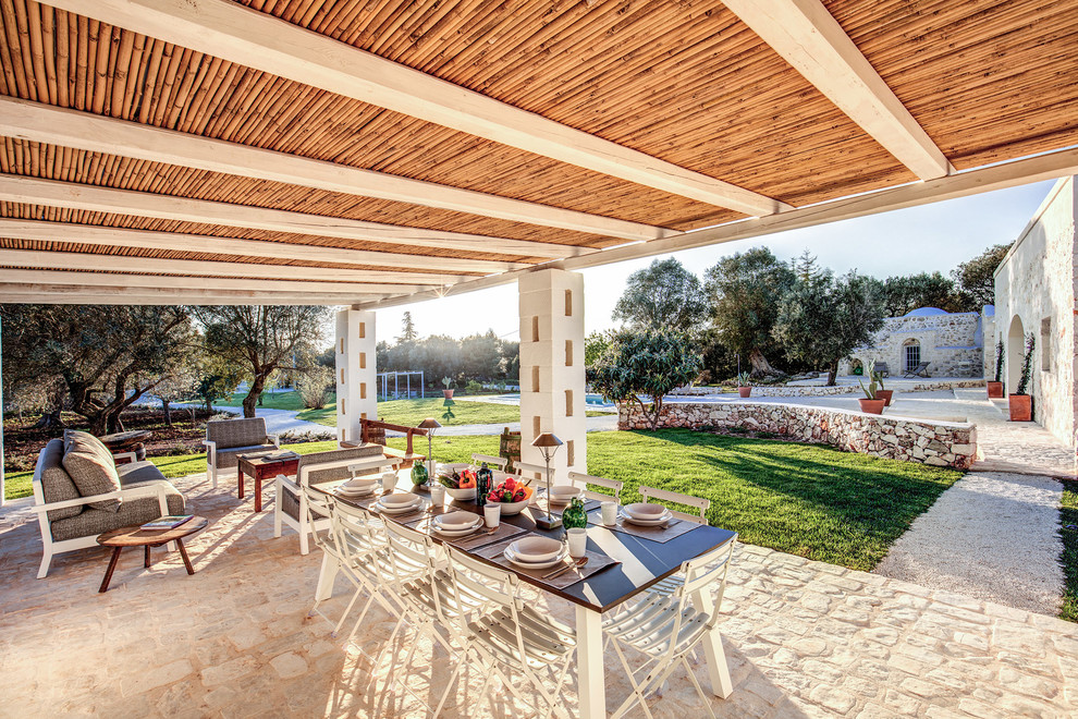 Foto di un patio o portico mediterraneo dietro casa con un tetto a sbalzo