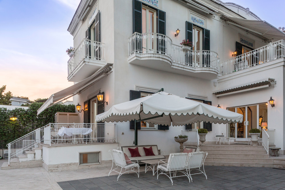 Esempio di un patio o portico mediterraneo davanti casa con un parasole