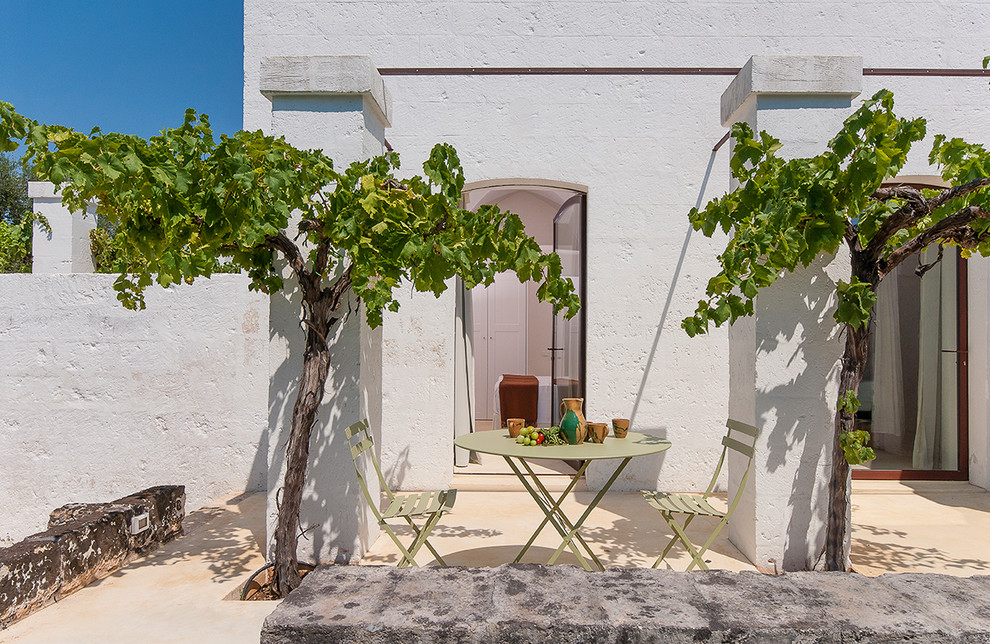 Diseño de patio mediterráneo pequeño sin cubierta en patio lateral con adoquines de piedra natural