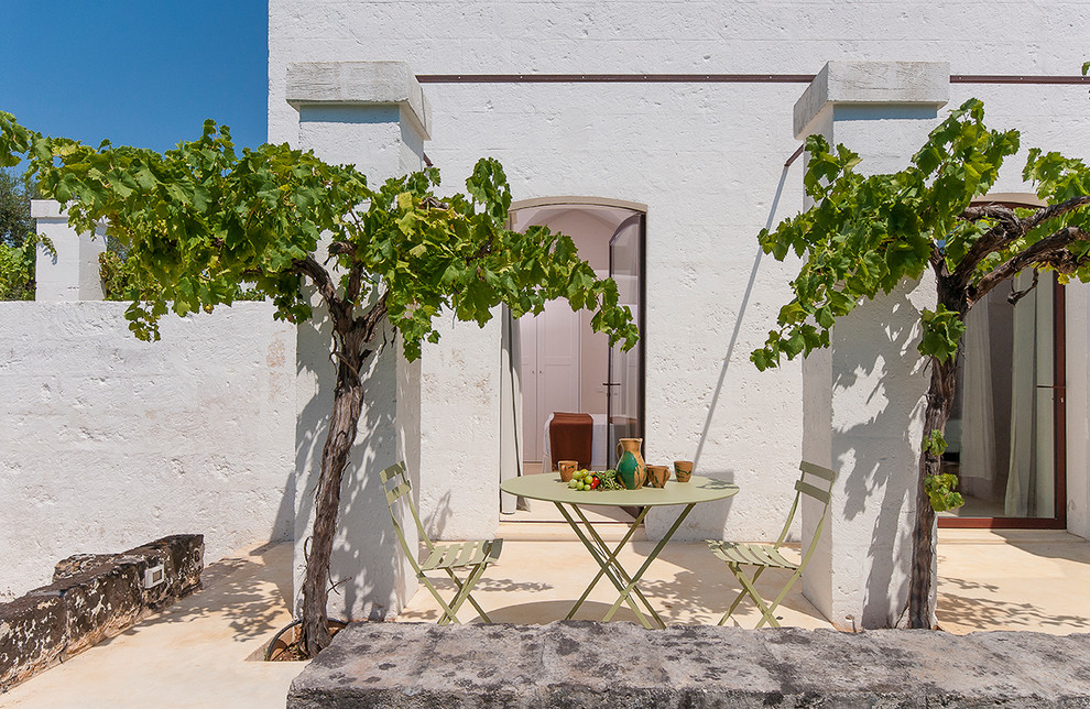 Design ideas for a small mediterranean side patio in Bari with no cover and natural stone paving.