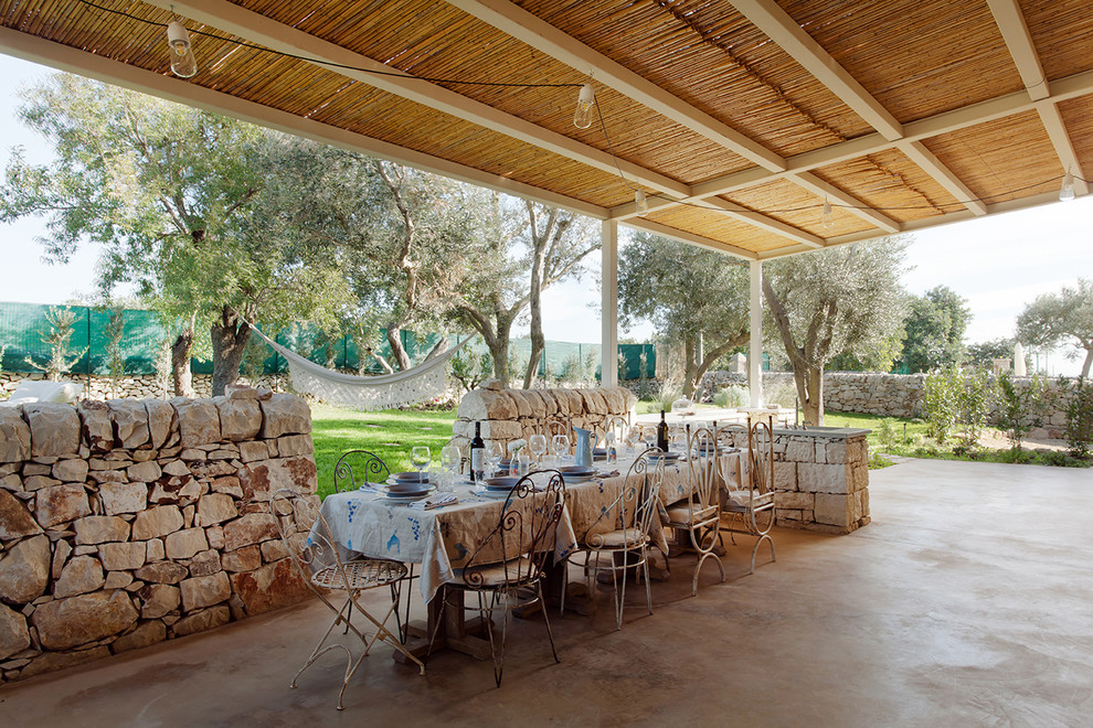 Diseño de patio mediterráneo en patio trasero con cocina exterior, adoquines de hormigón y pérgola