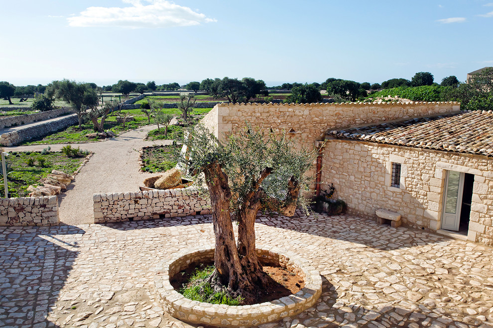 Immagine di un patio o portico mediterraneo in cortile con pavimentazioni in pietra naturale