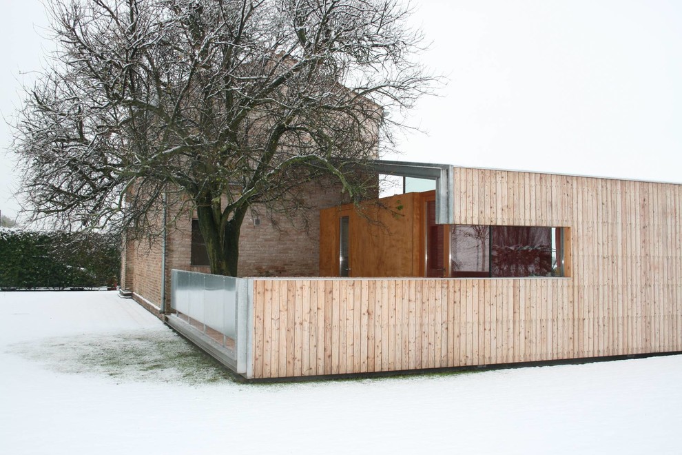 Inspiration pour une terrasse en bois latérale design de taille moyenne avec une extension de toiture.