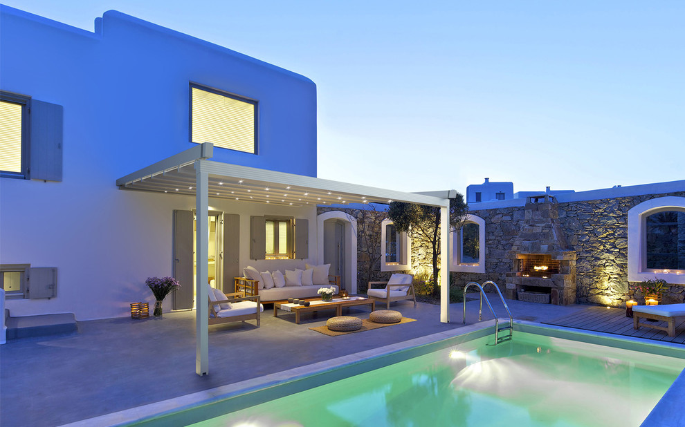 Immagine di un patio o portico mediterraneo dietro casa con pavimentazioni in cemento e una pergola