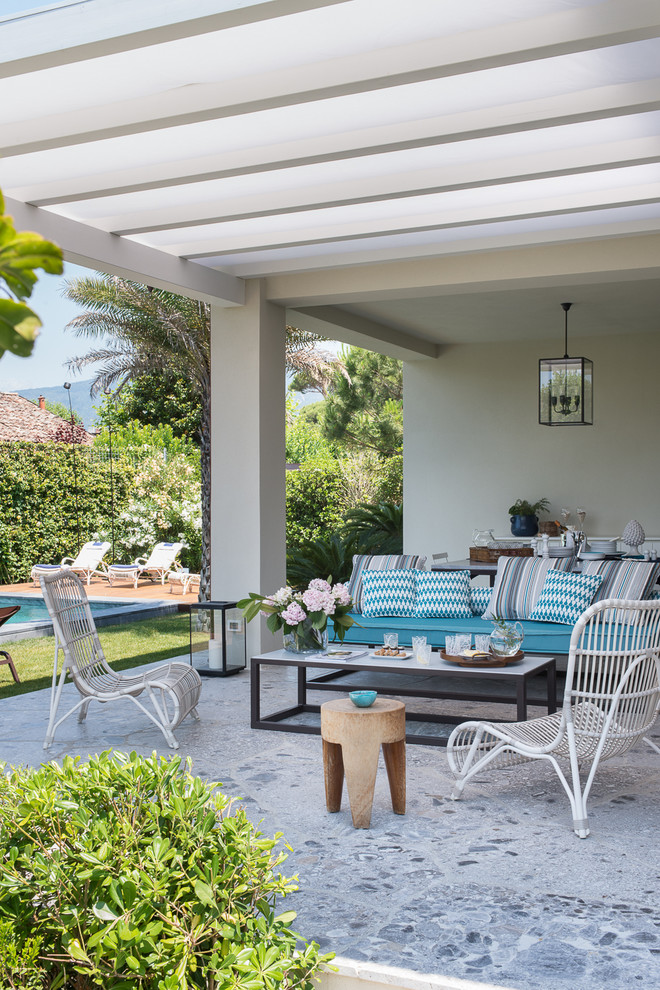 Esempio di un patio o portico stile marinaro di medie dimensioni e dietro casa con pavimentazioni in pietra naturale e una pergola