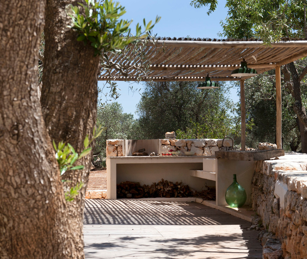 Aménagement d'une petite terrasse méditerranéenne avec une pergola et des pavés en pierre naturelle.