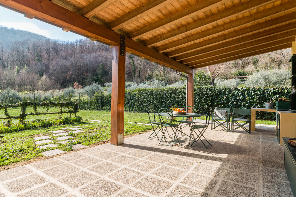 Exemple d'une terrasse arrière méditerranéenne avec une cuisine d'été, des pavés en béton et un auvent.