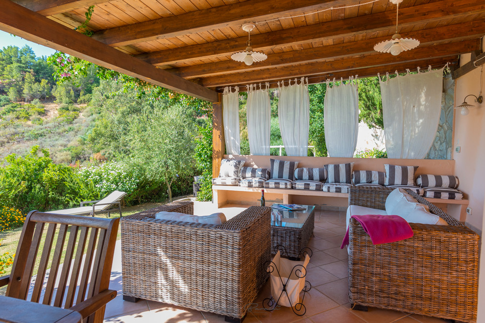 На фото: двор среднего размера на заднем дворе в средиземноморском стиле с покрытием из плитки и навесом с