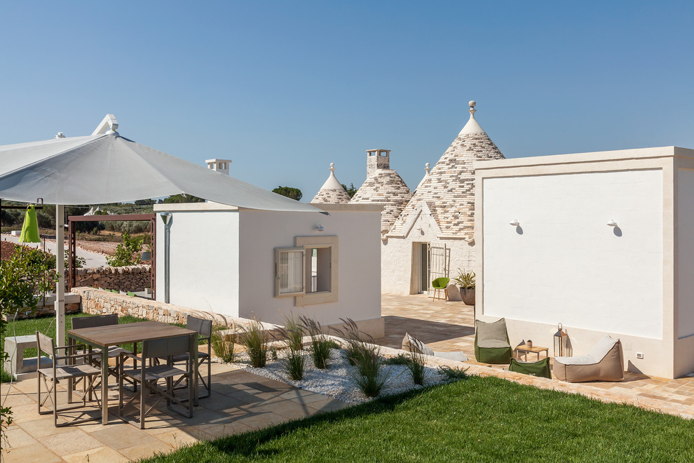 Пример оригинального дизайна: большой двор на заднем дворе в средиземноморском стиле с покрытием из каменной брусчатки