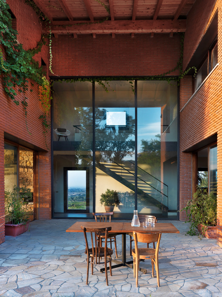 Foto di un ampio patio o portico country dietro casa con pavimentazioni in pietra naturale