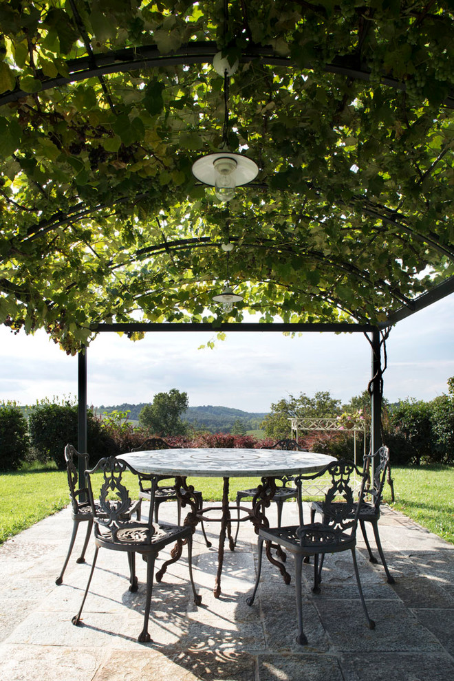 Inspiration for a timeless patio remodel in Milan with a pergola