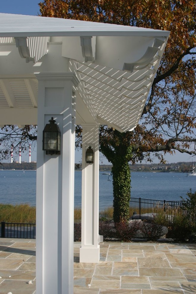 Idee per un patio o portico stile marino dietro casa con pavimentazioni in pietra naturale e un gazebo o capanno