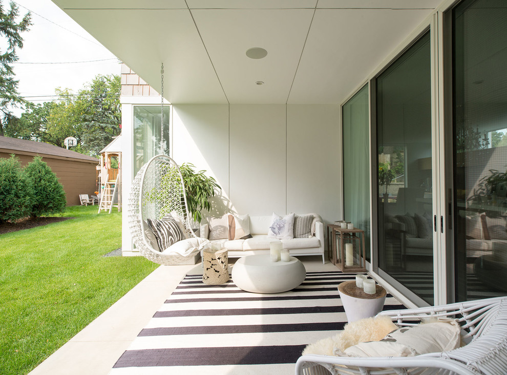 Inspiration pour une grande terrasse latérale design avec une dalle de béton et une extension de toiture.