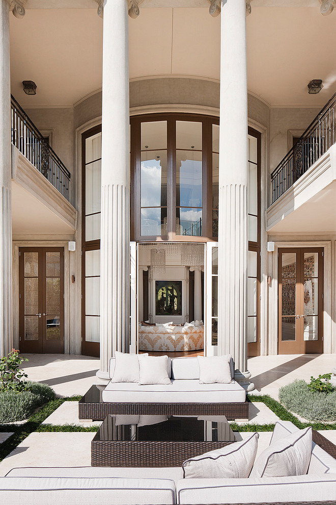 Immagine di un grande patio o portico classico dietro casa con pavimentazioni in pietra naturale