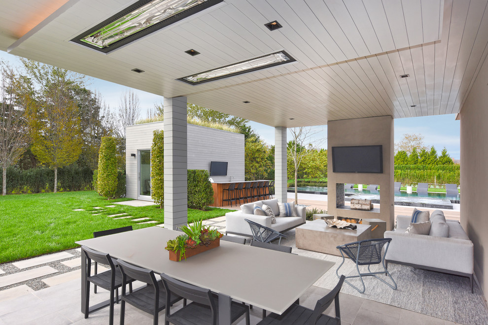 Inspiration for a huge contemporary backyard patio remodel in New York with a fireplace