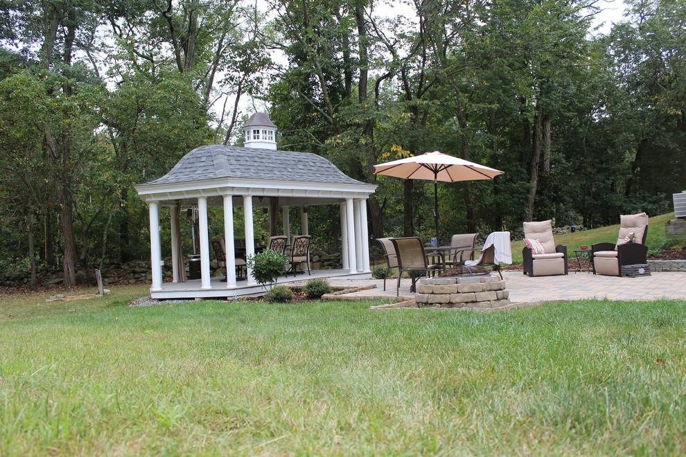 Ejemplo de patio tradicional renovado grande en patio trasero con cocina exterior, adoquines de piedra natural y cenador