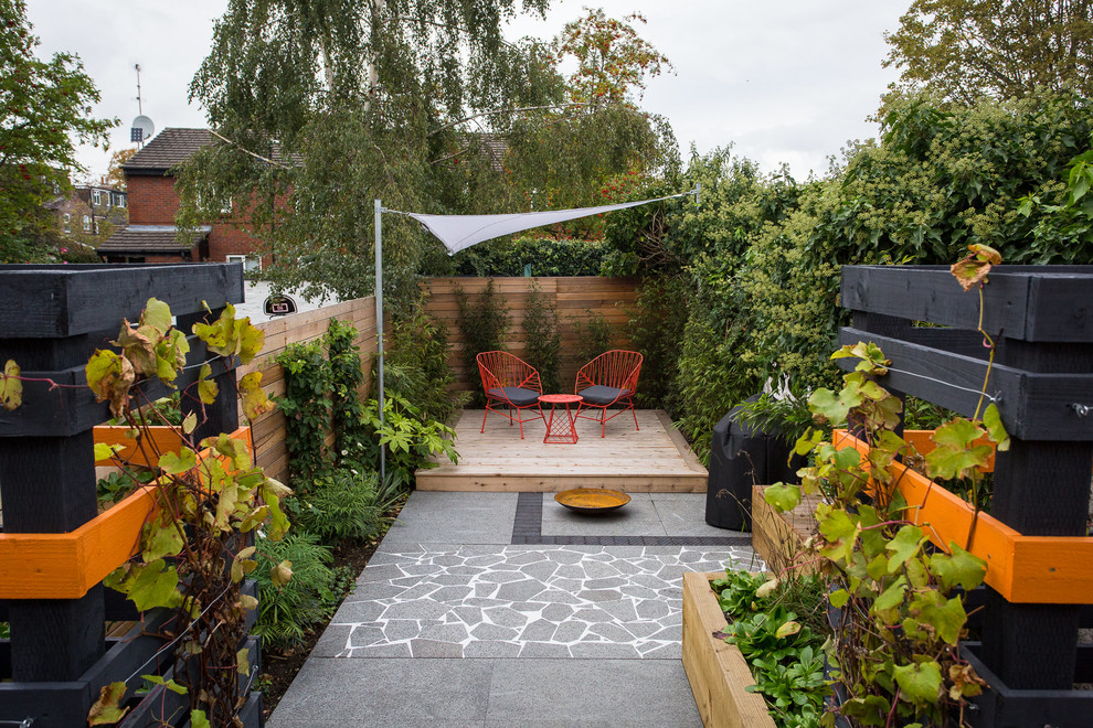 Стильный дизайн: двор в современном стиле с растениями в контейнерах, настилом и козырьком - последний тренд