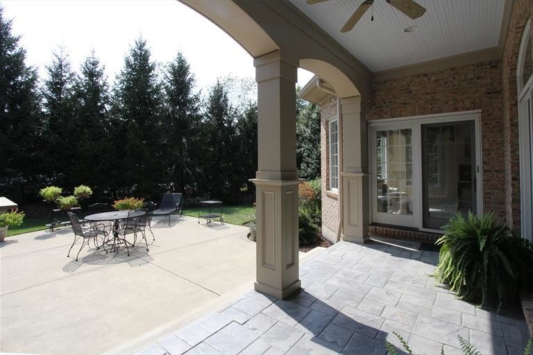На фото: двор среднего размера на заднем дворе в стиле неоклассика (современная классика) с покрытием из декоративного бетона и навесом