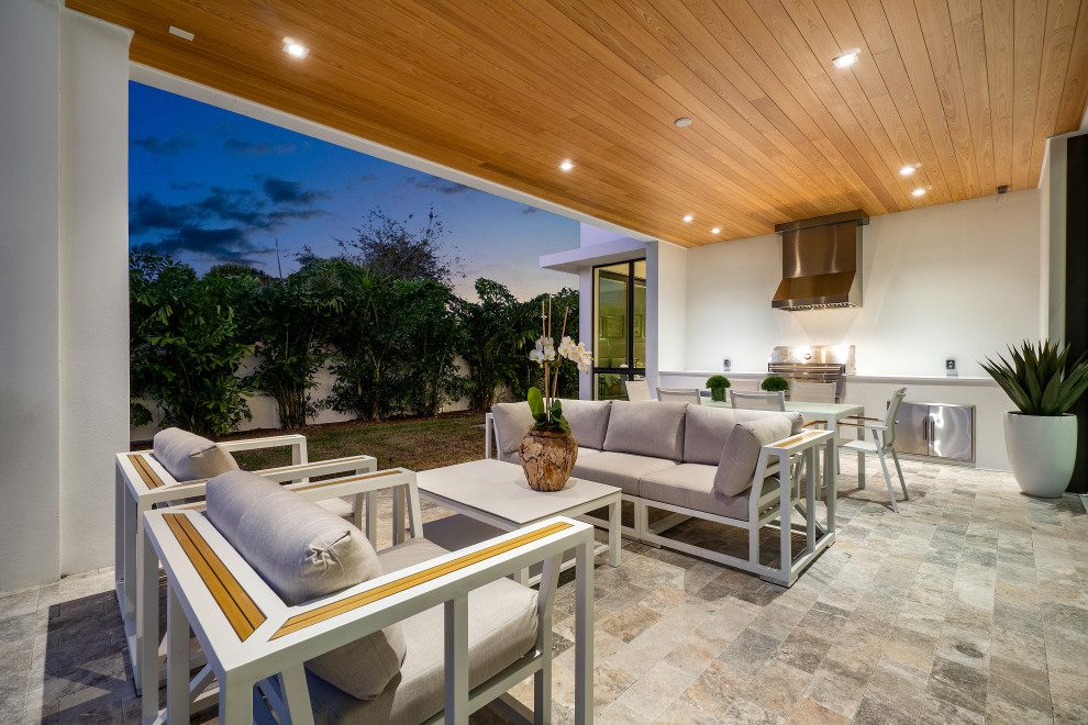 Photo of a medium sized contemporary back patio in Miami with an outdoor kitchen, tiled flooring and a roof extension.