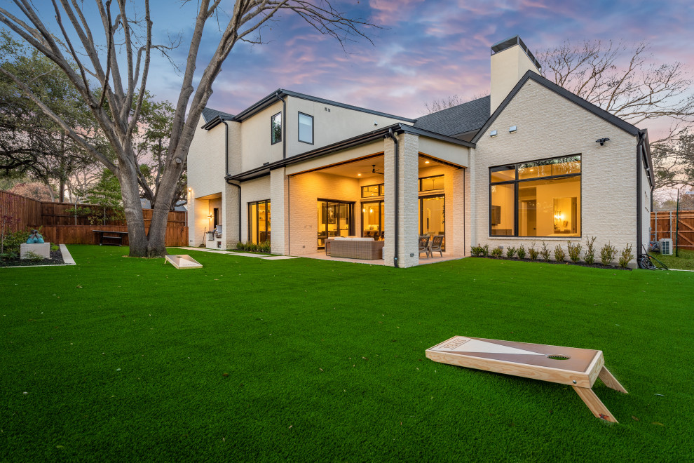 Inspiration pour une grande terrasse arrière minimaliste avec un foyer extérieur, des pavés en béton et une extension de toiture.