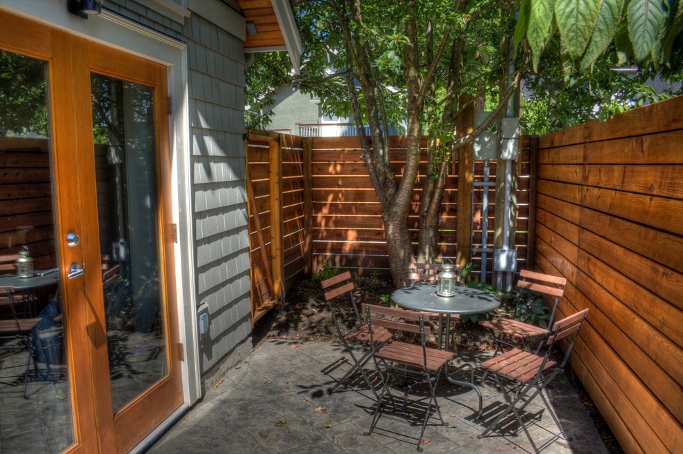 Immagine di un patio o portico tradizionale dietro casa con lastre di cemento