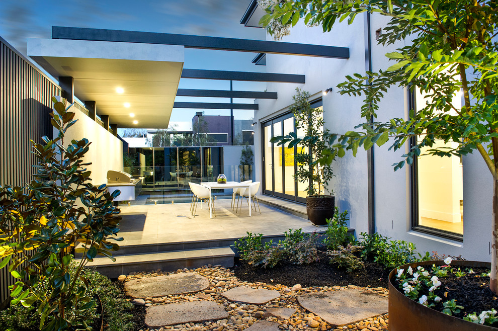 Esempio di un patio o portico minimal di medie dimensioni e dietro casa con lastre di cemento e una pergola