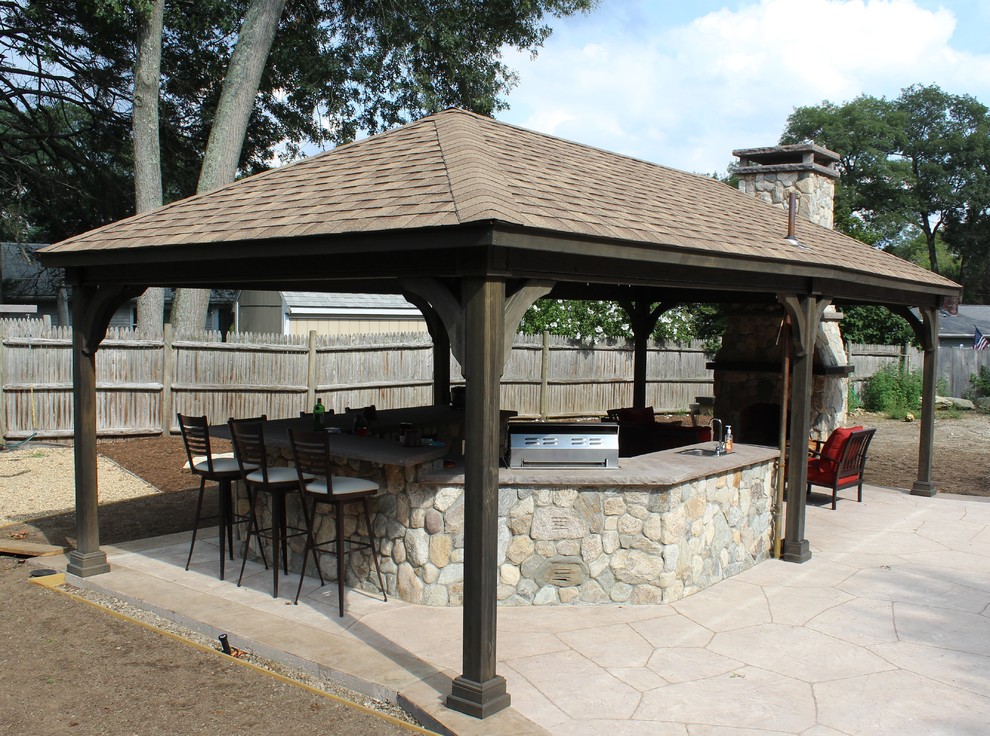 Cette image montre une grande terrasse arrière traditionnelle avec une cuisine d'été, des pavés en pierre naturelle et un gazebo ou pavillon.