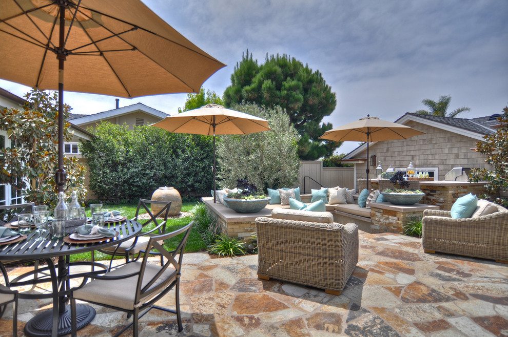 Example of a beach style stone patio design in Los Angeles with no cover