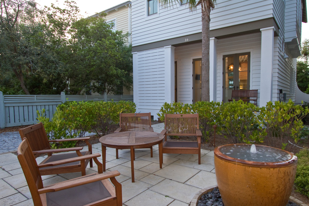 Photo of a medium sized nautical back patio in Miami with a water feature, tiled flooring and no cover.
