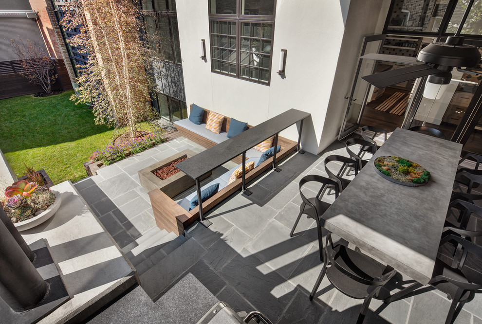 Пример оригинального дизайна: двор среднего размера на заднем дворе в современном стиле с покрытием из каменной брусчатки и местом для костра без защиты от солнца