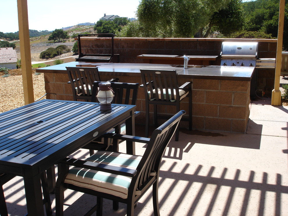 Cette image montre une terrasse arrière traditionnelle de taille moyenne avec une cuisine d'été, du béton estampé et une pergola.