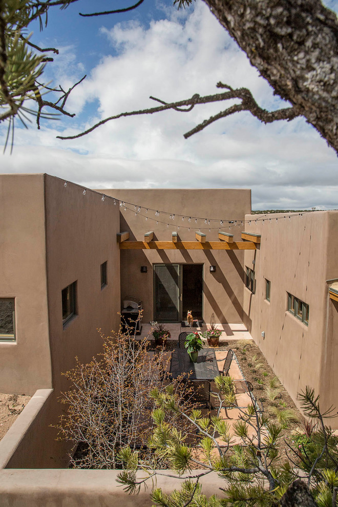 This is an example of a medium sized contemporary back patio in Albuquerque with concrete slabs and a roof extension.